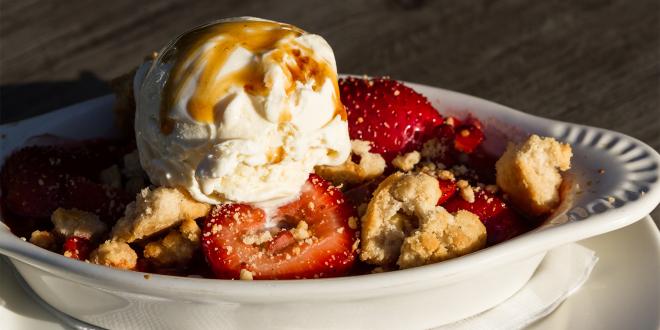 a dish of strawberry-rhubarb crisp topped with ice cream